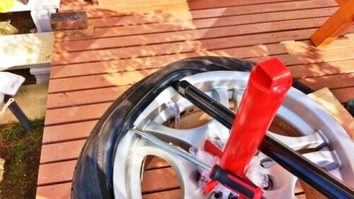 赤いタイヤチェンジャーの棒を軸にして、グル～っとレバーを回していけば、タイヤを取り外すことができる